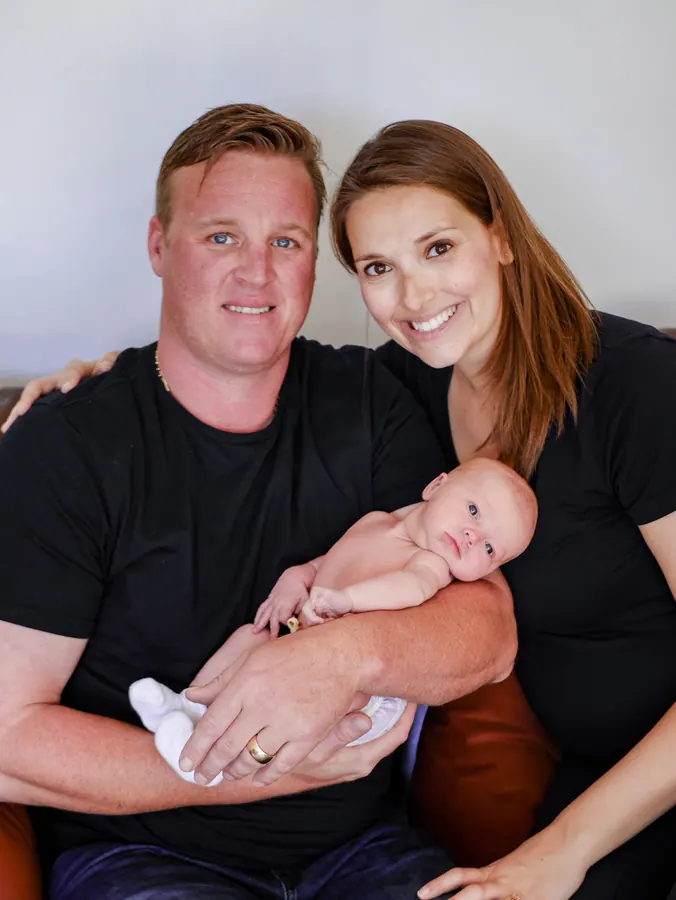 Courtney and her husband holding their first baby