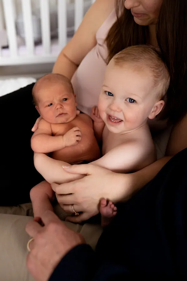 Courtney holding her newborn and her smiling toddler